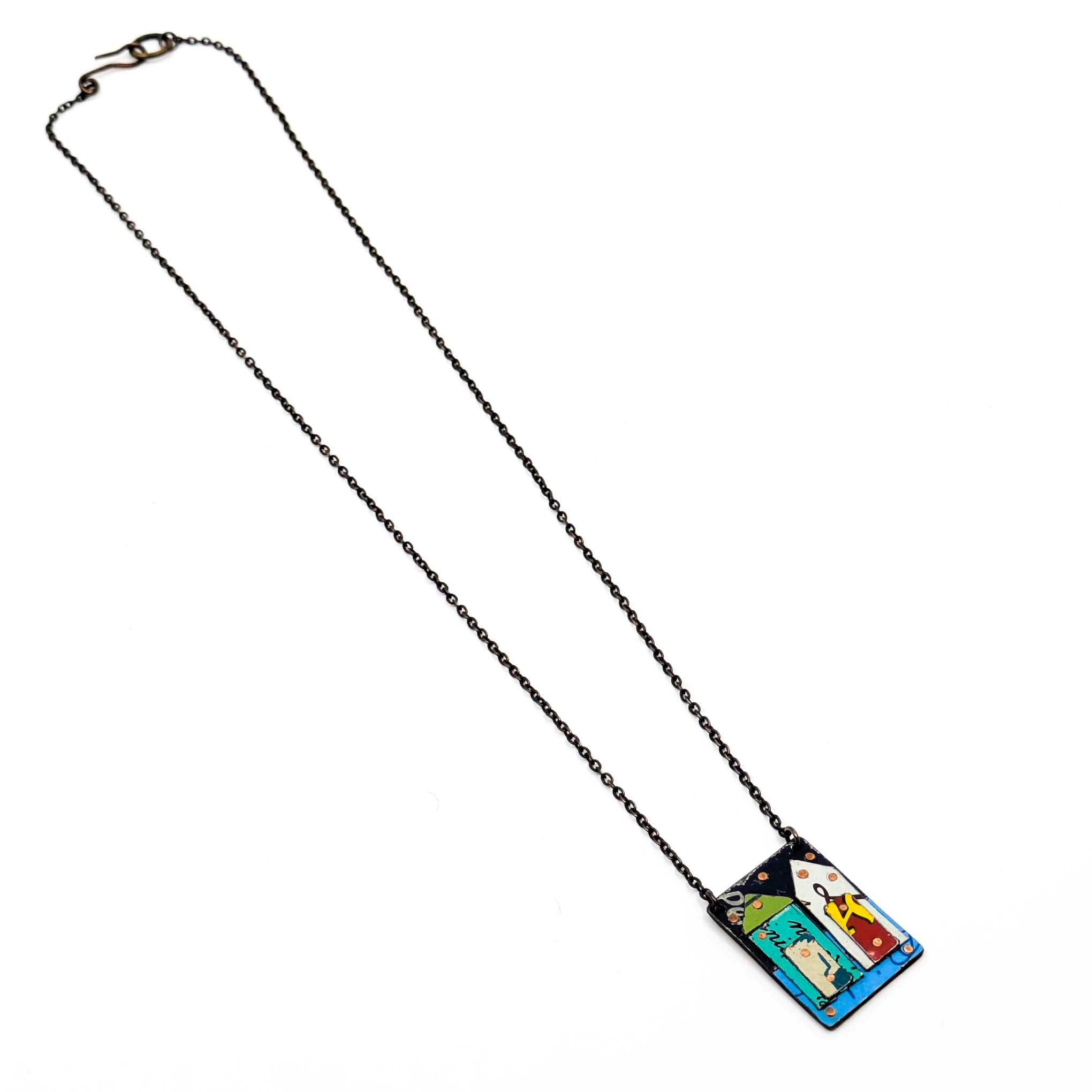 Necklace with a pendant featuring a colorful abstract house on a white background